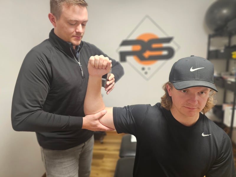 Physical therapist assessing shoulder movement at Rock Solid