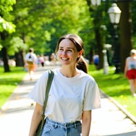 A person walking in the park on a bright summer day The photograph should be of their smiling face to reflect a feeling of warmth and calmness-1